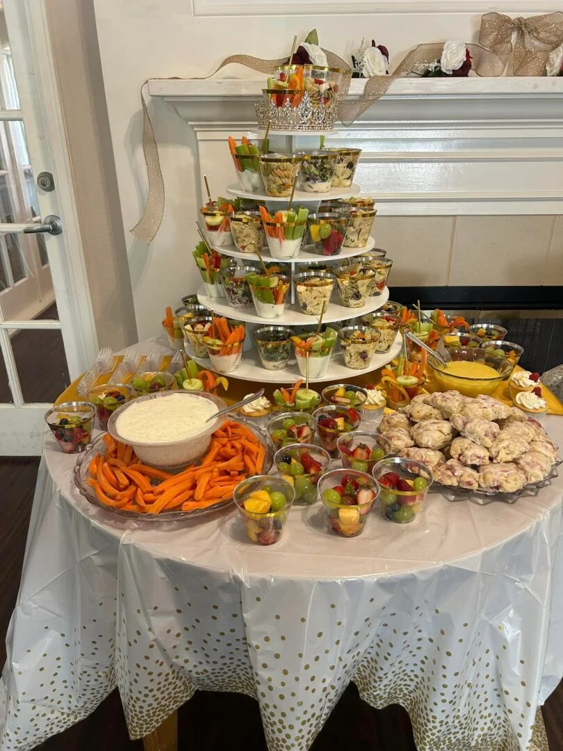 party table with tiered stand filled with grab-and-go treats and platters of other treats