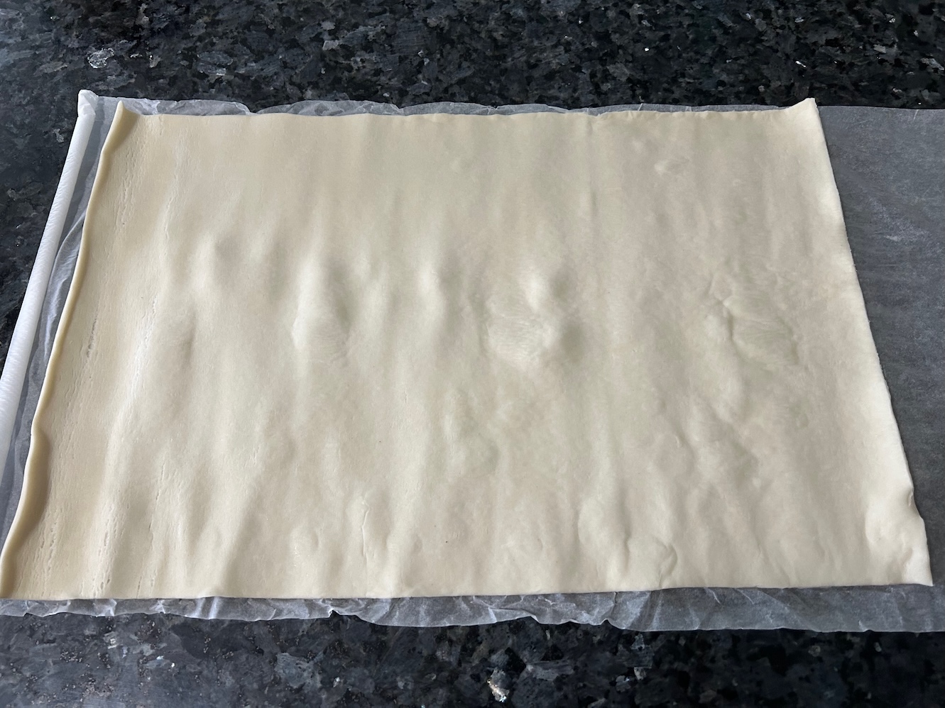 puff pastry rolled out flat on parchment paper