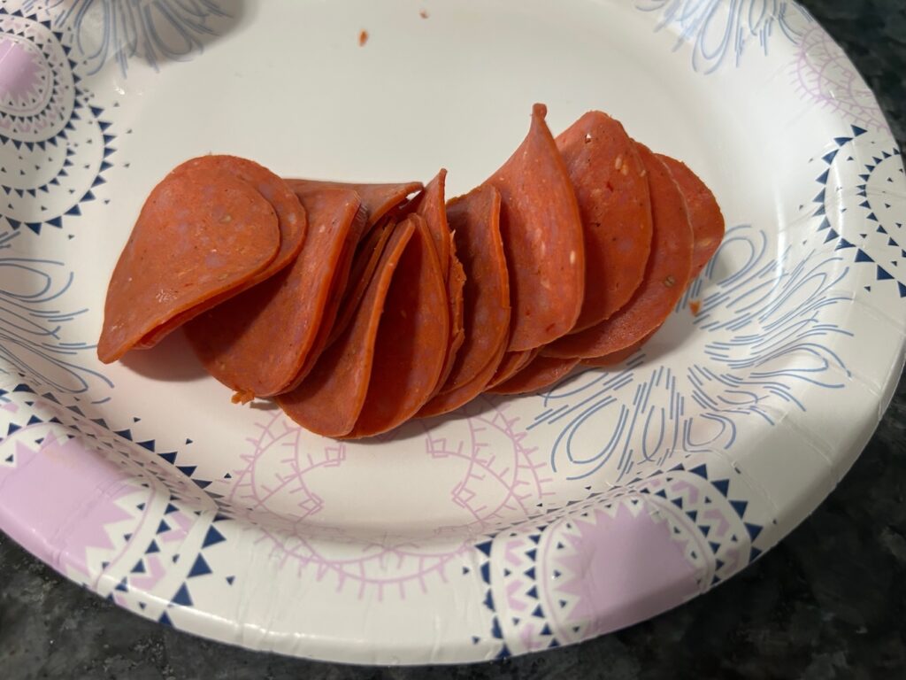 sliced pepperoni on paper place