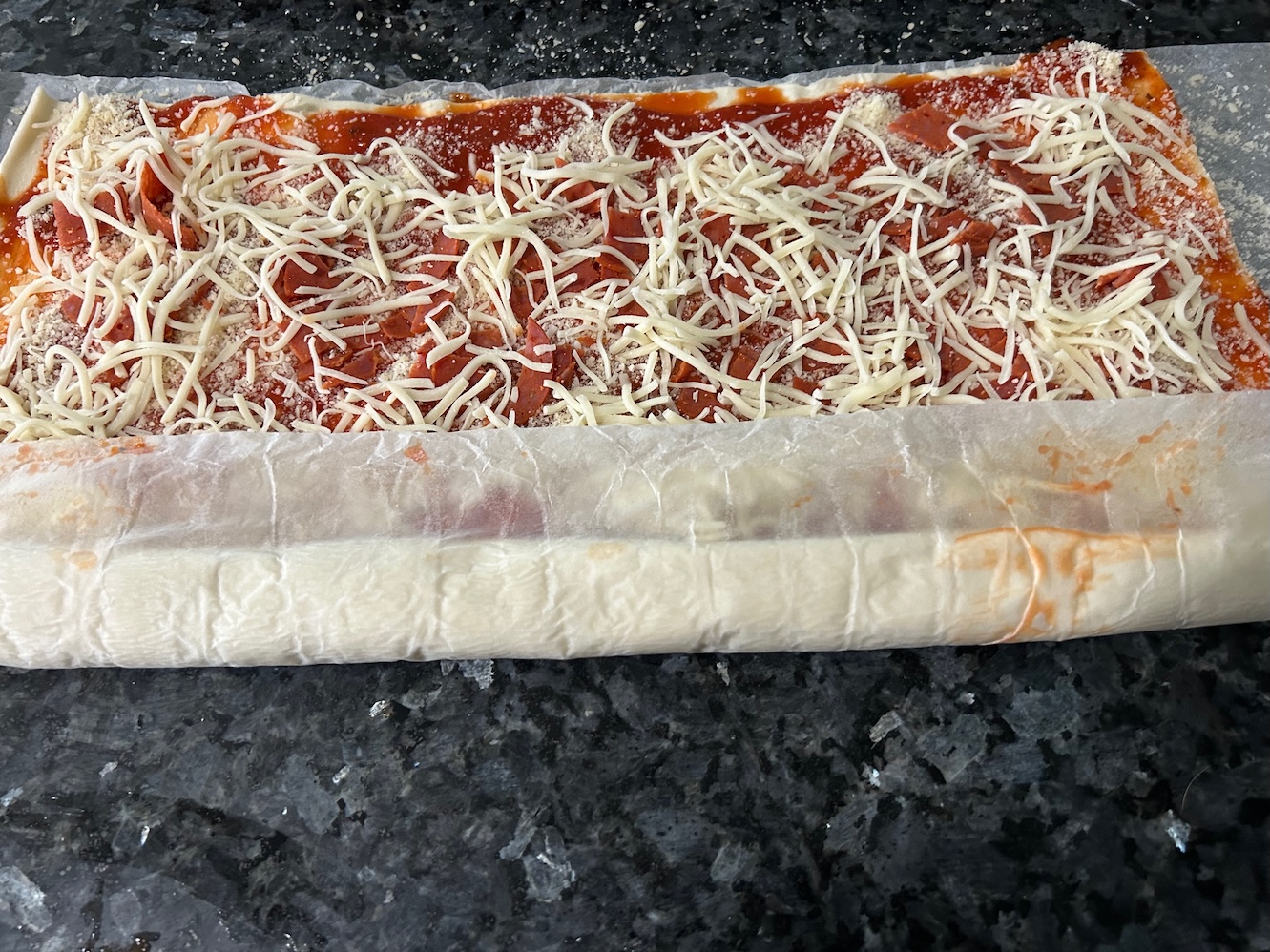 puff pastry in process of being rolled up into a log