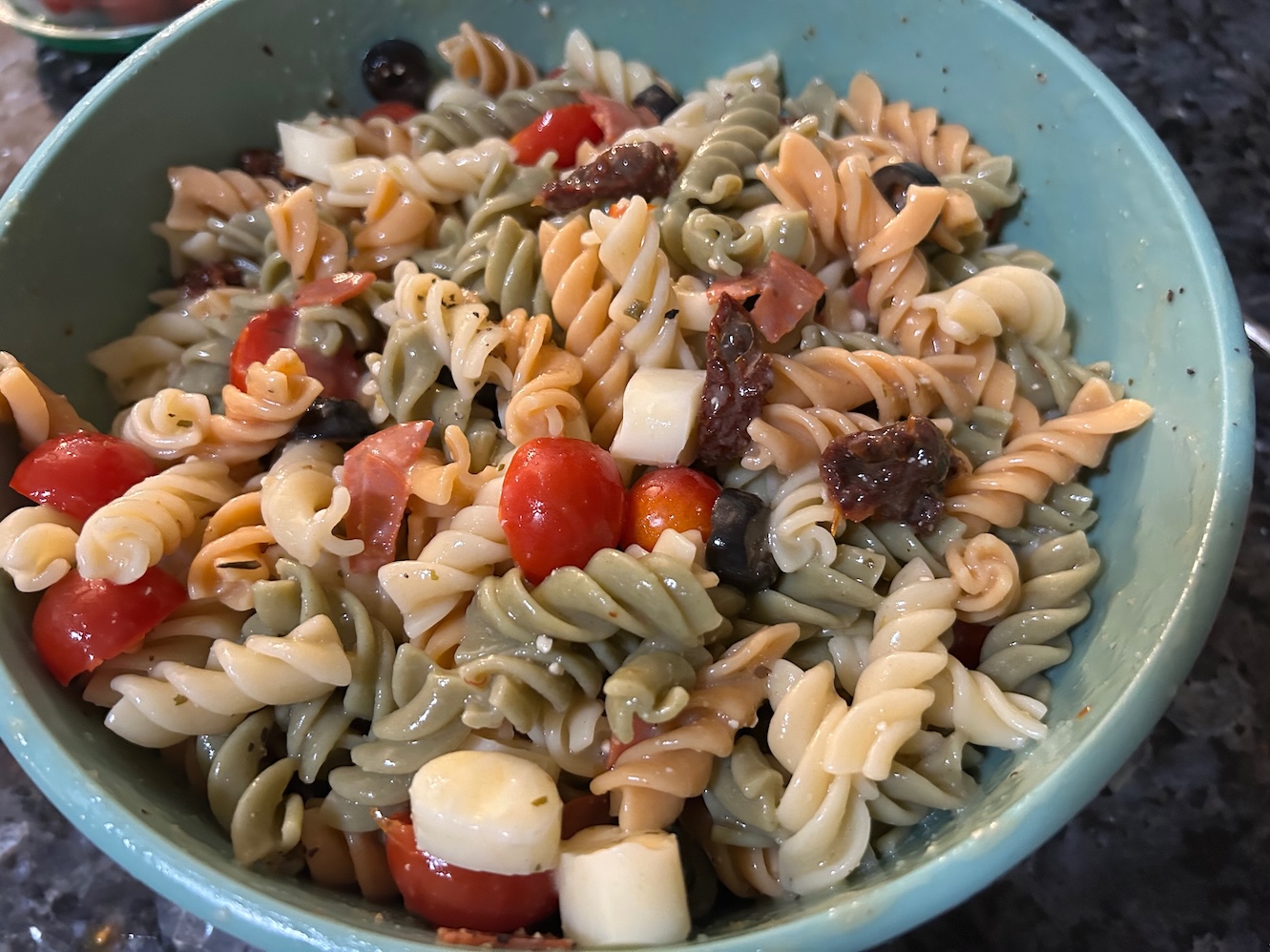 colorful pasta salad with rotini pasta and veggies, tossed in a bowl with dressing. Texas: Creamy Italian Pasta Salad