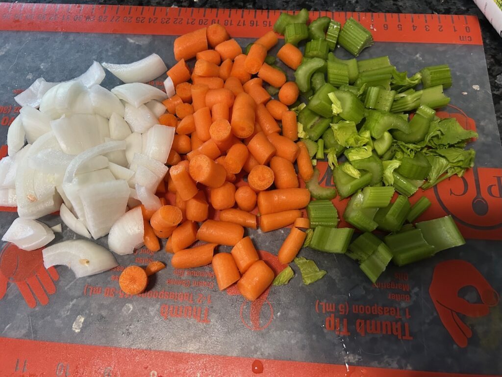 veggies cut up on cutting mat: onions, carrots, celery