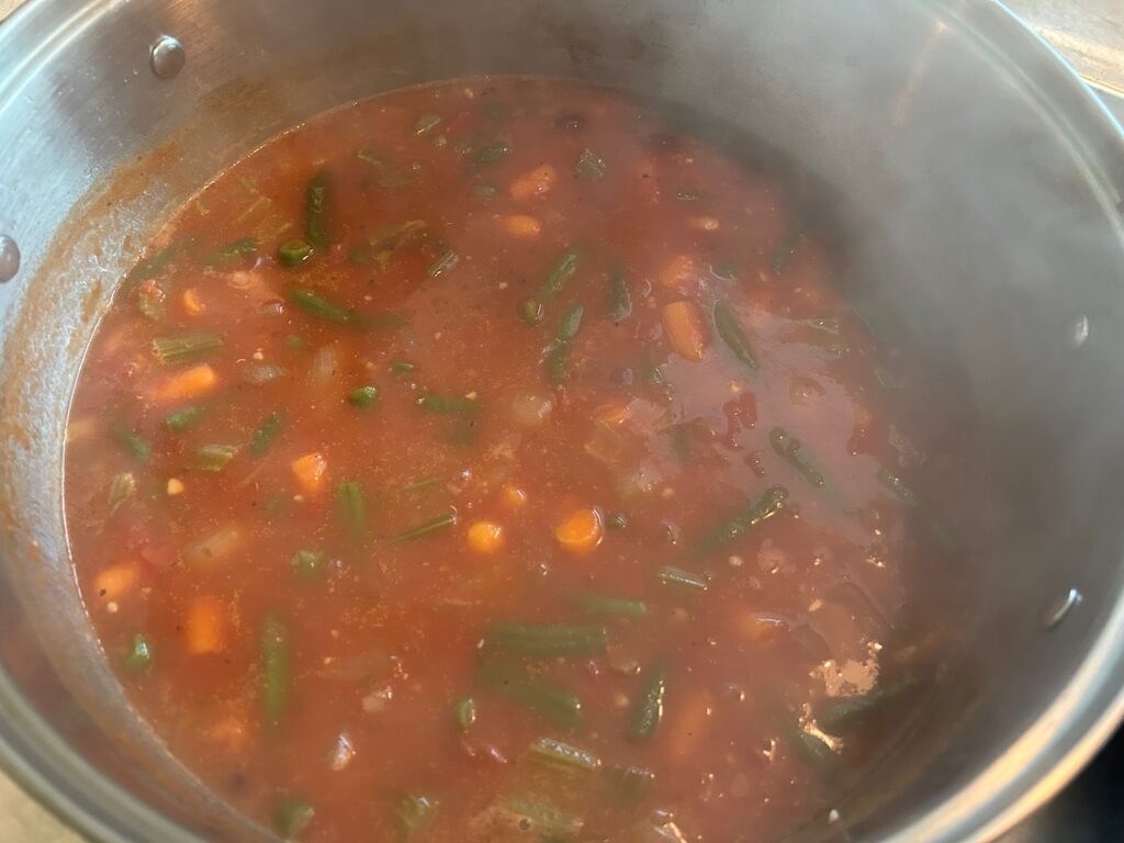 minestrone soup simmering in pot on stove